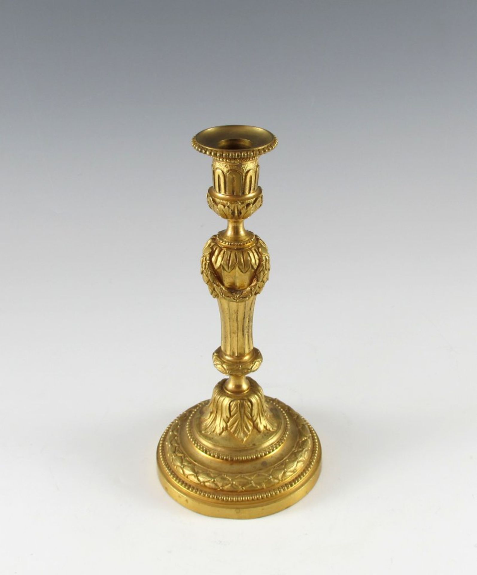 Bronze-doré-Leuchter. Runder Fuß mit Perlstab, Akanthus und Lorbeer. Balusterschäftung mit