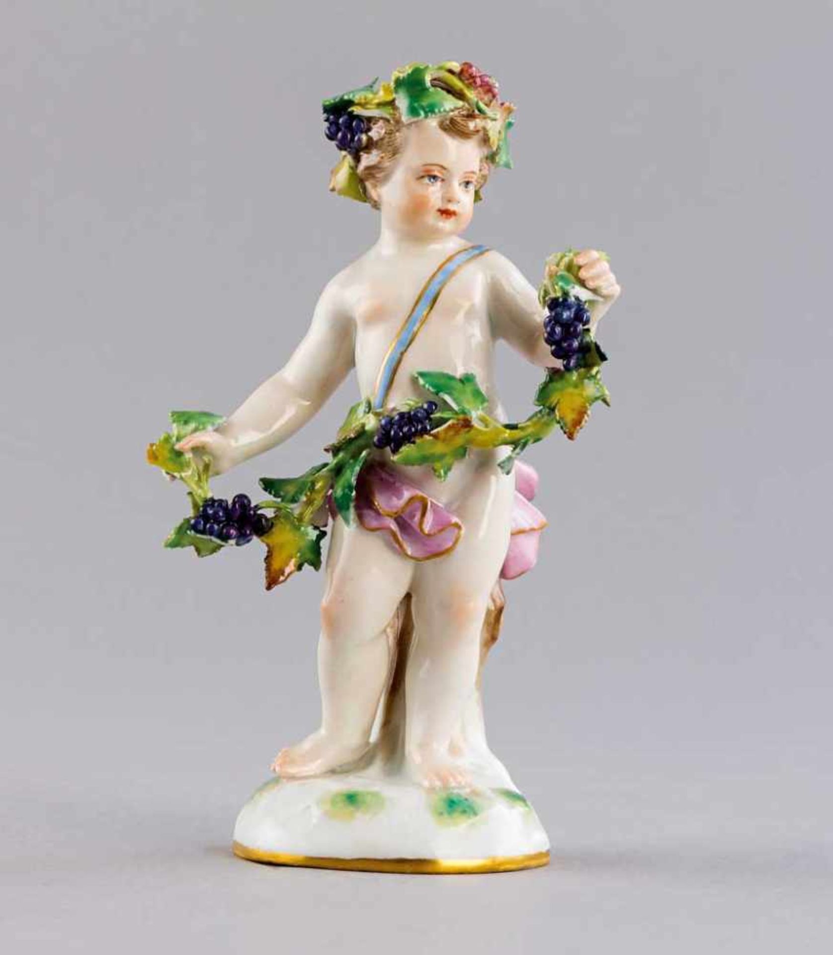 Bacchantenkind mit Trauben. Polychrom staffierte Figurine. Blaue Schwertermarke Meissen, 19./20. Jh.