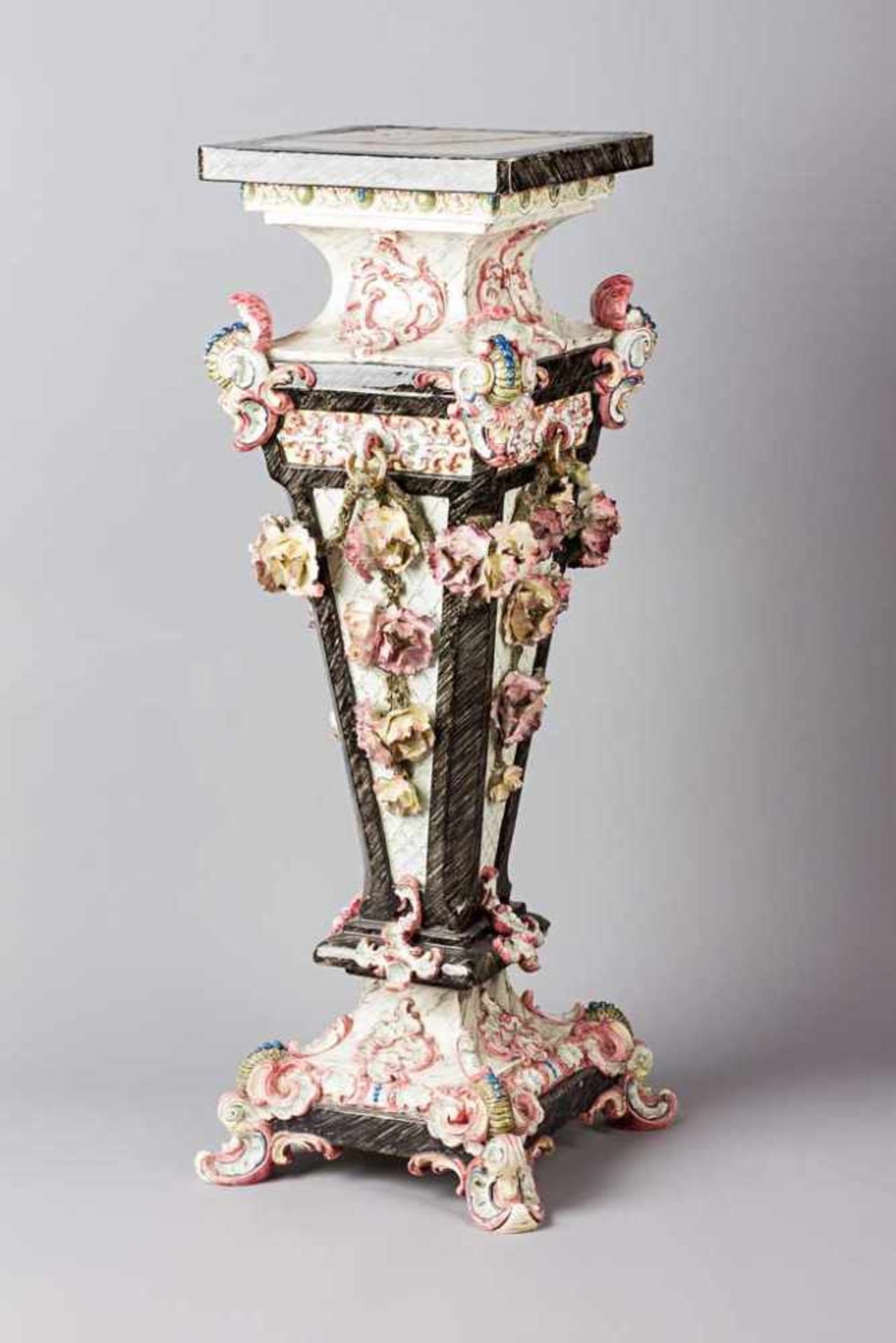 Keramiksäule auf vier Rocaillenfüßen. Aufgesetzte Blüten, Akanthus und Rankenwerk. Polychrom bemalt.