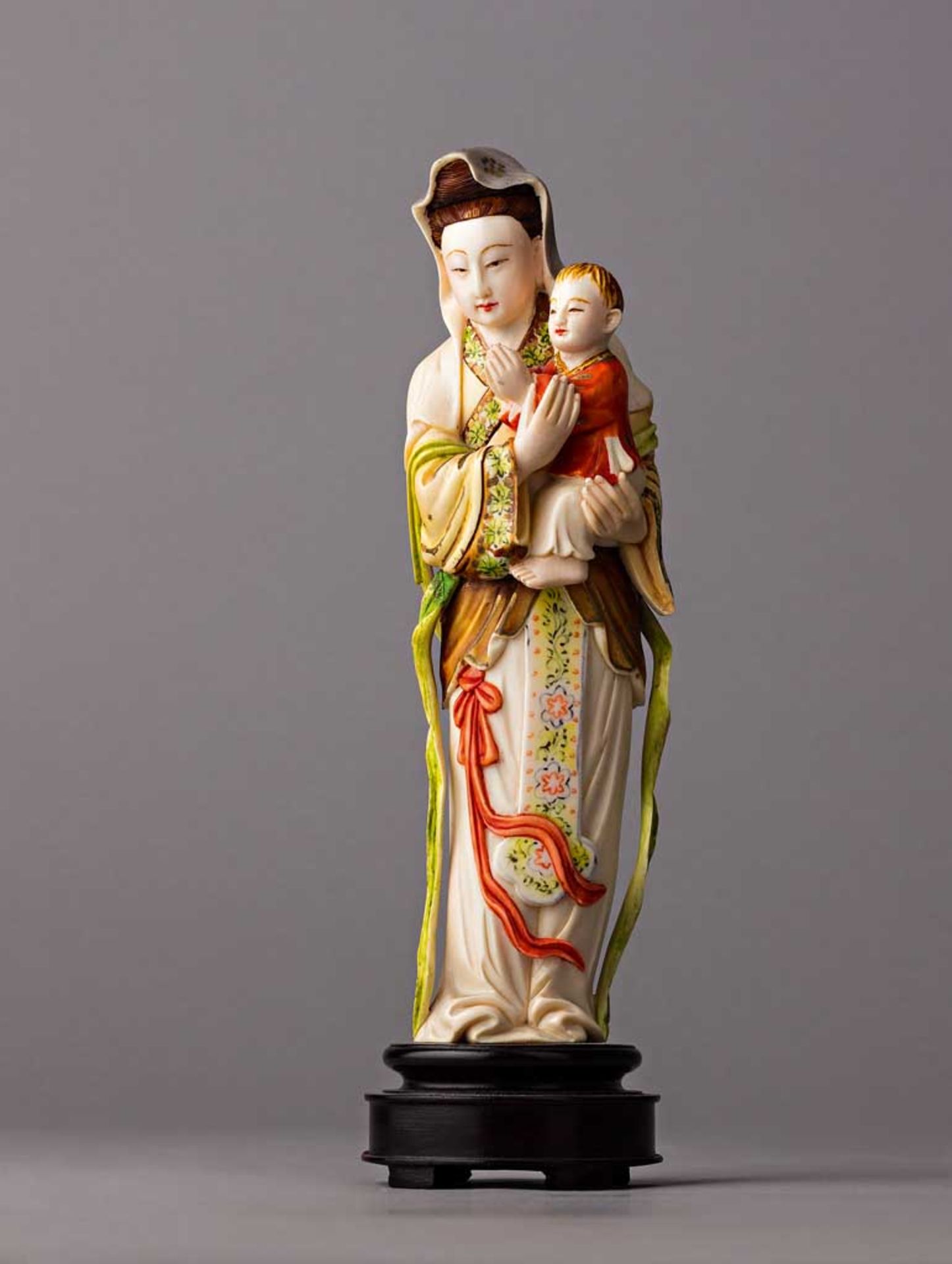 Kuanyin mit Kind. Polychrom bemalte Elfenbeinfigur. China, 1. H. 20. Jh. H 19,5 cm