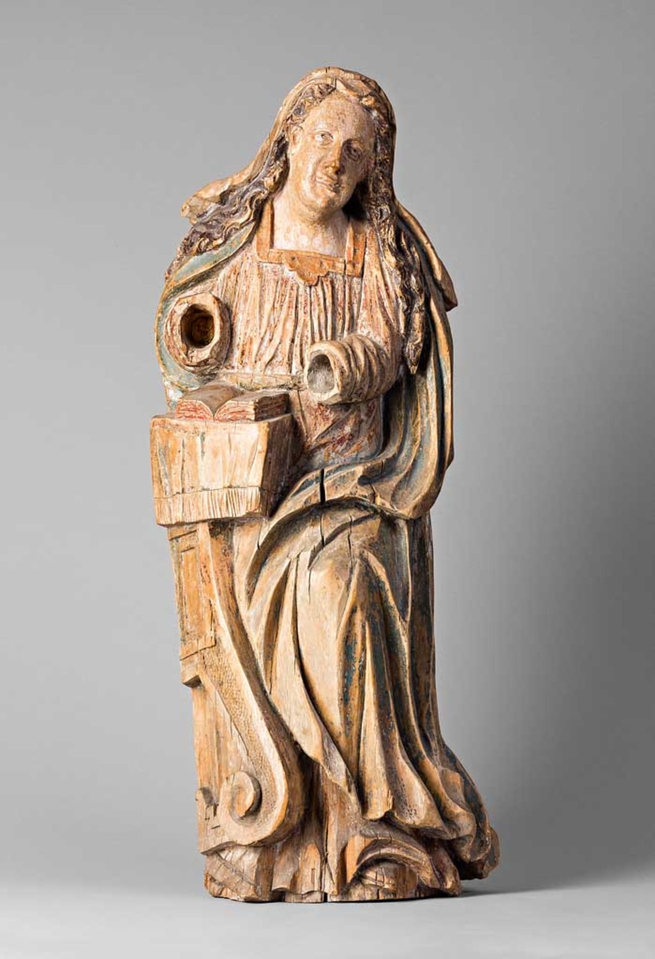 Heilige mit aufgeschlagener Bibel. Hände fehlen. Holz mit Resten von Fassung. Um 1700? H 70 cm