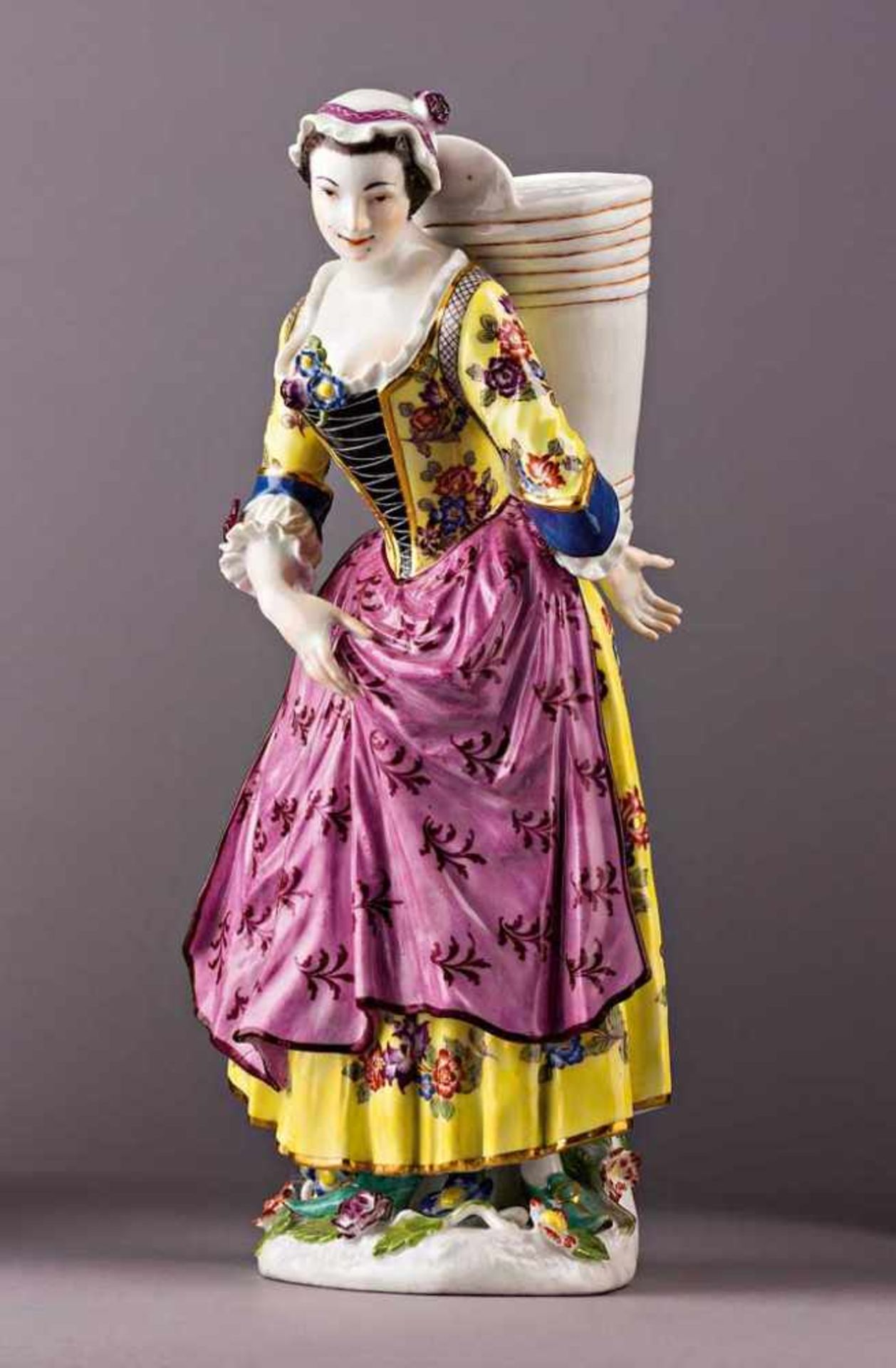 Winzerin mit Bütte. Polychrom staffierte Figurine (Tafelaufsatzfigur mit Blumensteckvase). Mit