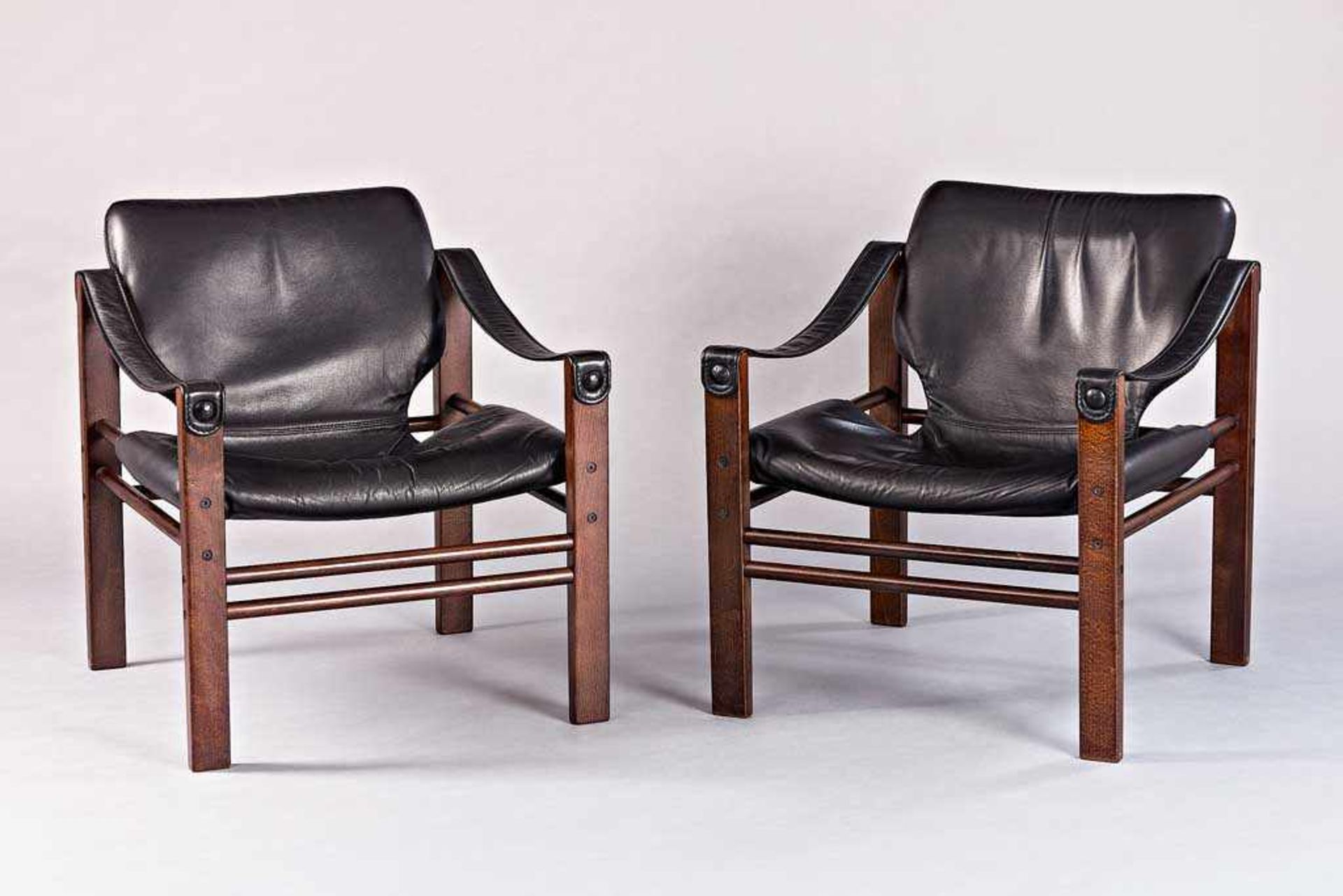 Paar Safari Lounge Chairs. Buche und schwarzes Lederpolster. Entwurf Maurice Burke für Arkana.