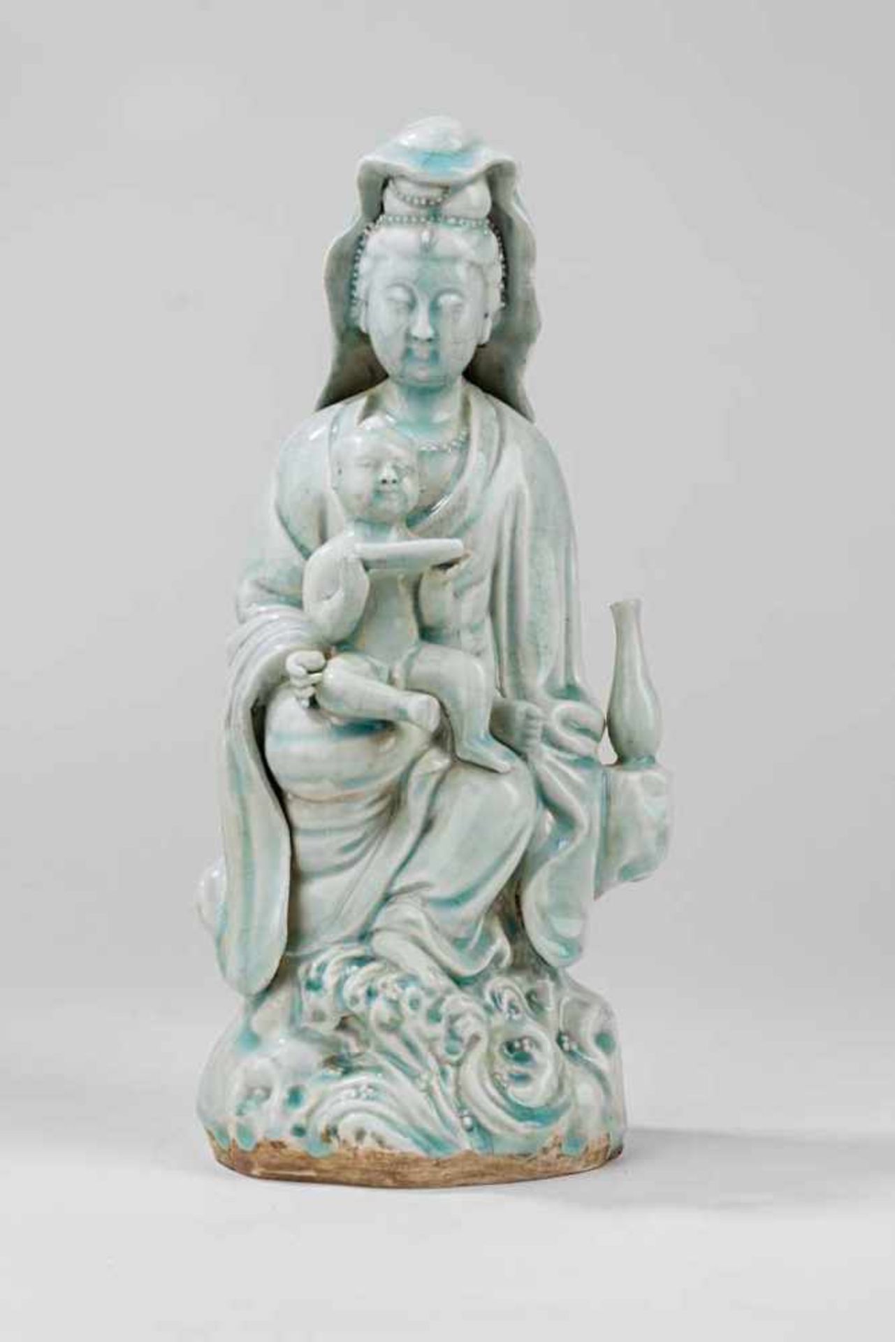Kuanyin. Auf dem Schoß Kind mit Schriftrolle. Ching-pai-Glasur. China, 19. Jh. H 32 cm