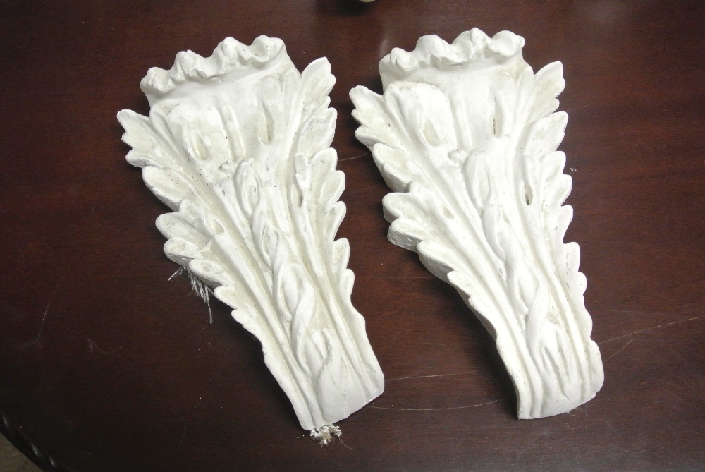 COLLECTABLES - A pair of plaster cast decorative corbels, each measuring 31cm tall.