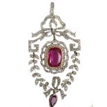 An attractive antique diamond, platinum and red tourmaline pendant, c1910, the bow design top with