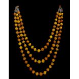 An unusual vintage Baltic amber necklace, c1930, fastened to the front with three rows of ovoid