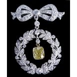 A belle epoque diamond and fancy yellow and platinum brooch/pendant, the bow design top suspending a