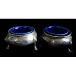 Two Victorian salts, circular on three pad feet, earthenware liners, London 1877, 88grms