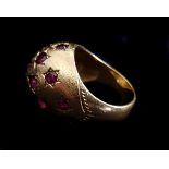 A bombe ruby set dome ring, the fifteen stones pave set as stars on textured ground of 14k yellow