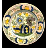 An 18thC Dutch Delfware plate, decorated in polychrome colours with large peony type flowers and