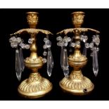 A pair of brass table lustres, the drip pans pierced with leaves supporting glass bead and lustre