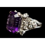 An amethyst and diamond dress ring, the raised central stone set with four brilliant stones to the