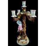 A German porcelain five light candelabra, modelled as a young boy climbing a ladder to pick apples