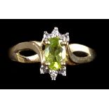 A marquise cut peridot and diamond chip ring set in 10k gold, ring size L