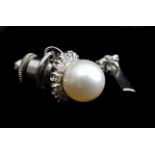 A cultured pearl and diamond tie stud, the pearl encircled by a ring of diamonds, in white metal,