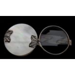 A Georgian mother of pearl and white metal mounted folding magnifying glass, circular with still