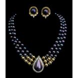 A Three strand necklace of black cultured pearls, with 19ct yellow gold mounted teardrop form