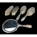 A silver backed dressing table set, comprises hand mirror, two hair brushes and two clothes brushes,