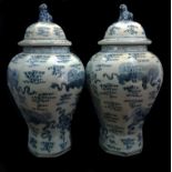 Two modern Chinese porcelain temple vases and covers, blue and white, decorated with dragons amid