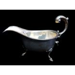 A silver sauceboat, on three volute feet with 'c' scroll handle, Birmingham 1935, kings & queens