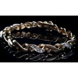 A diamond and 10ct yellow gold bracelet, formed of 'S' scroll links of alternating diamond set and