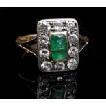 An emerald and diamond ring, the central emerald of baguette cut