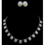 A greenish 'white jade' set necklace composed of fifteen oval stones on yellow metal chain