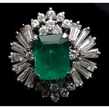 An emerald and diamond ring, the central emerald, probably Columbian, cut stone within a diamond
