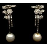 A pair of pearl and diamond drop earrings, the 10mm pearls suspended on baguette cut 'stems' from