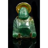 A carved spinach jade pendant in the form of a seated Buddha, yellow metal mounted with hat and