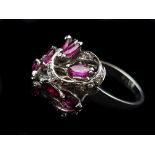 A ruby and diamond dress ring, the marquise cut rubies set in foliate scrolls of brilliant diamonds,