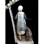 Lucy Casson - 'South Bank' a found object sculpture of tin, formed as a woman with dog resting on