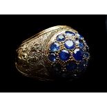 A Burmese sapphire and yellow gold dome ring, the 19 stones concentrically set over shoulders