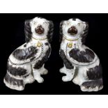 A pair of Staffordshire pottery spaniels, c1860, modelled seated with separate front leg, gilt