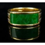 A Jadite and two colour gold ring, set with a curved rectangular panel of deep green jadite, 6mm x