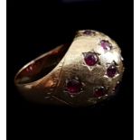 A bombe ruby set dome ring, the fifteen stones pave set as stars on textured ground of 14k yellow