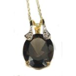 A chocolate coloured topaz and diamond pendant set with two small diamond chips in 9ct yellow