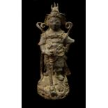 A Chinese cast iron figure of a warrior standing upon a pierced rocky outcrop, some traces of red,
