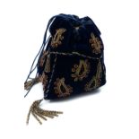 A velvet and beadwork drawstring purse, decorated with 'jewelled' paisly motifs in red and gold with