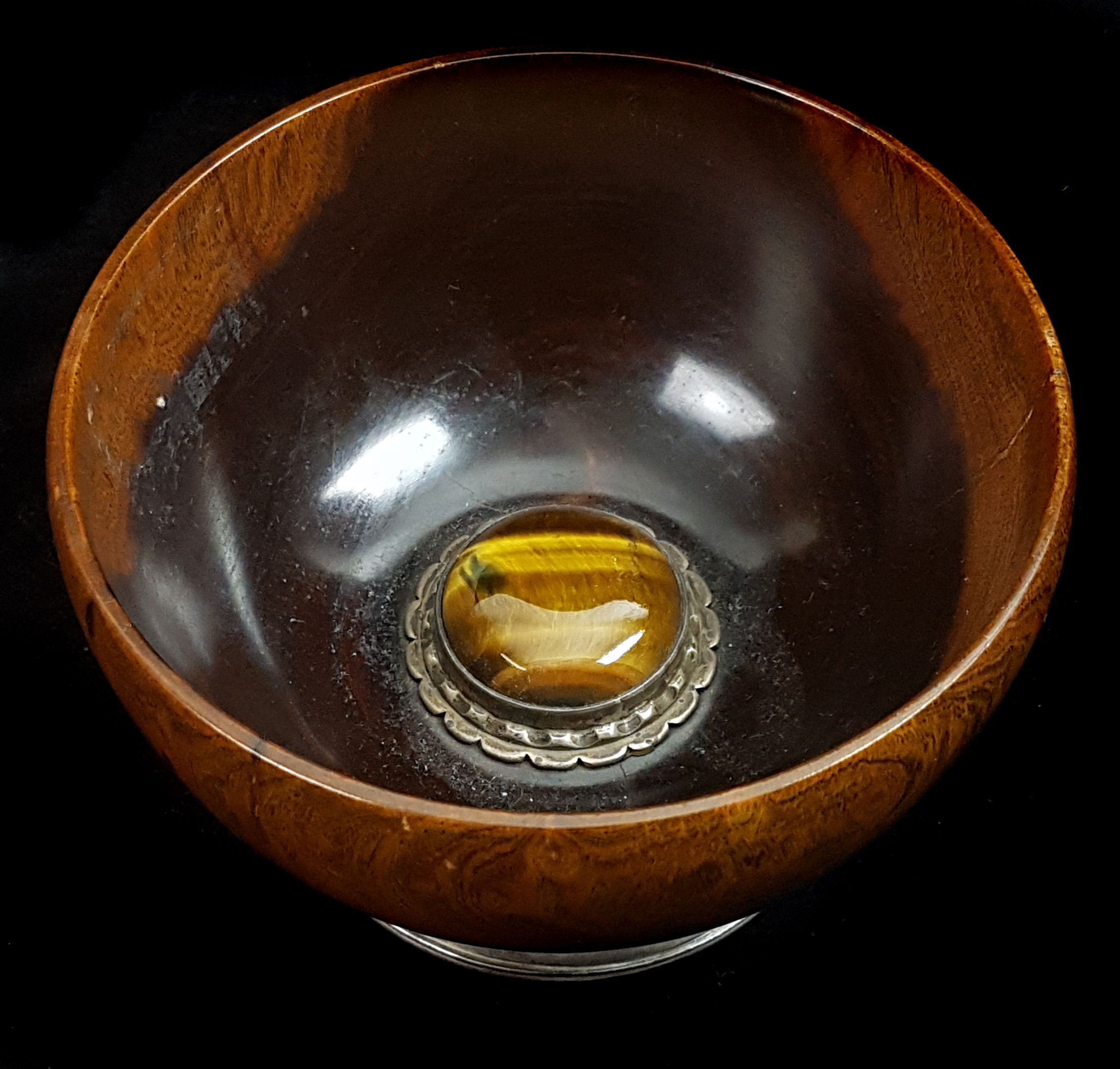 A turned wood Mazer bowl, the interior set with a large cabouchon Tigers Eye stone with metal mount