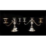 A pair of silver plated on copper three light candlesticks, ornate knopped stem on stepped