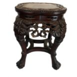 A Chinese hardwood carved stand, of quatre foil shaped top, inset with variegated red/ochre