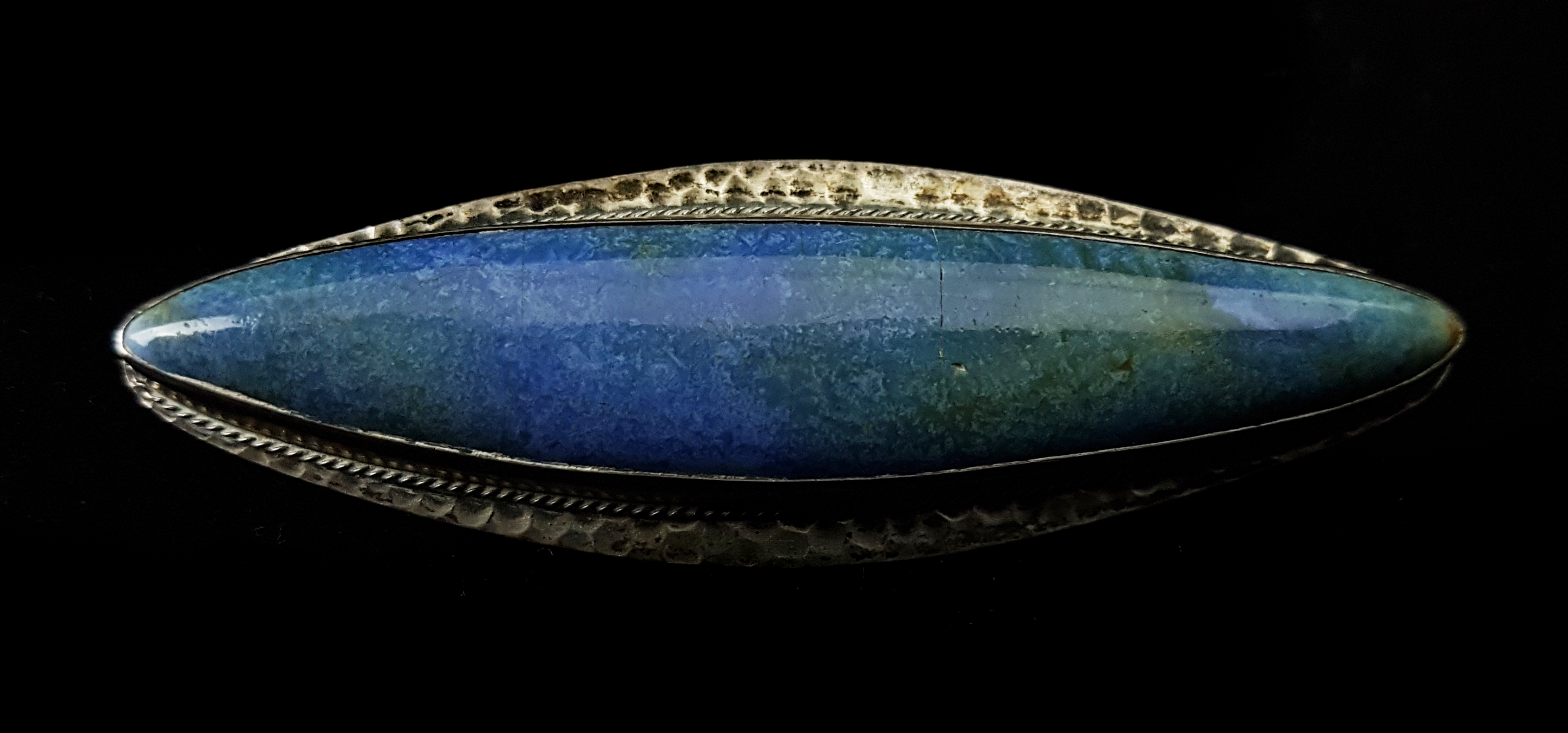 A Ruskin Pottery white metal mounted brooch/pendant, the blue elliptical plaque within planished