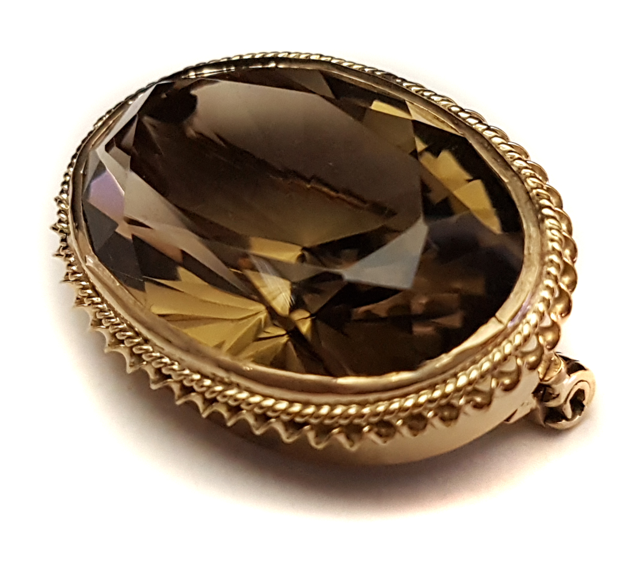 A smokey topaz and 9ct gold brooch/pendant, oval set in rope and barley twist oval mount, pin and