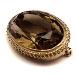 A smokey topaz and 9ct gold brooch/pendant, oval set in rope and barley twist oval mount, pin and