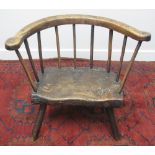 EARLY 19TH CENTURY WELSH PRIMITIVE ASH AND ELM LOW ELBOW CHAIR with slab seat on three turned legs.