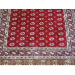 KASHMIRI RED GROUND BOKARA DESIGN, FINELY WOVEN RUG. 155 x 216cm.