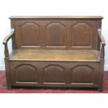 18TH CENTURY DESIGN OAK SETTLE, having three panelled back under a moulded cornice with open arms,