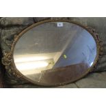 Gilt finish relief floral oval mirror.